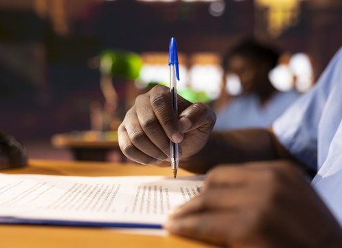 Student writing notes while studying